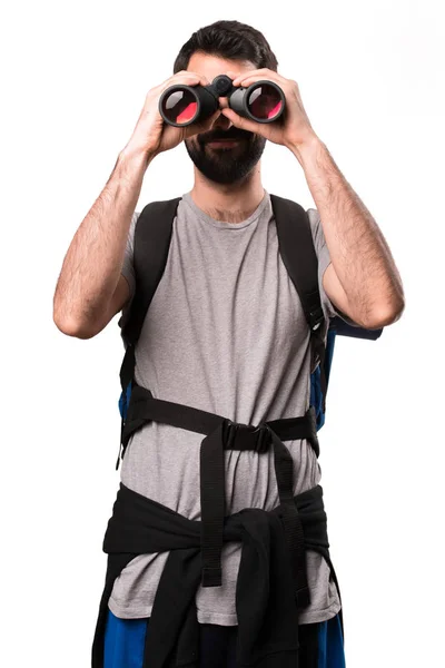 Schöner Backpacker mit Fernglas auf weißem Hintergrund — Stockfoto