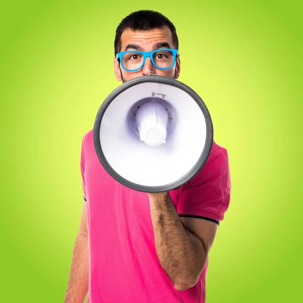 Homem com roupas coloridas gritando por megafone — Fotografia de Stock