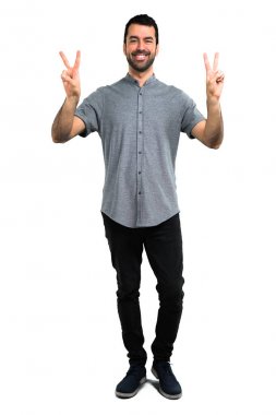 Gülümseyen ve zafer işaret gösteren yakışıklı adam