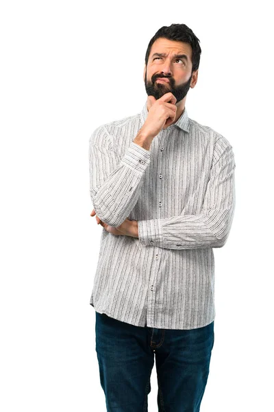 Homem bonito com barba de pé e pensando em uma ideia — Fotografia de Stock