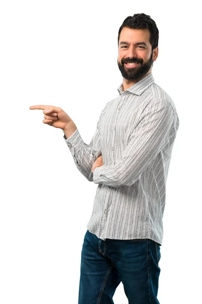 Jóképű férfi szakáll mutató ujjával az oldalon, és a jelen — Stock Fotó