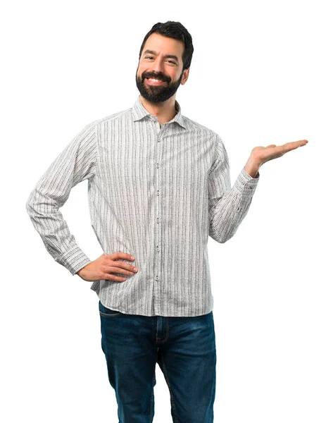 Handsome man with beard holding copyspace imaginary on the palm — Stock Photo, Image