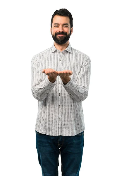 Homem bonito com barba segurando copyspace imaginário na palma da mão — Fotografia de Stock
