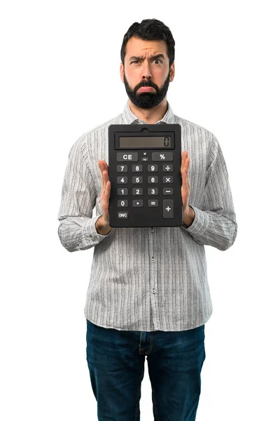 Homem bonito com barba segurando uma calculadora — Fotografia de Stock