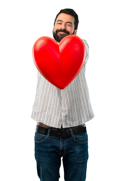 Красавчик с бородой держит в руках игрушку для сердца
