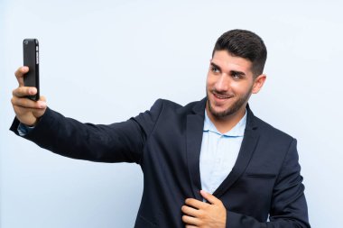 Izole mavi arka plan üzerinde yakışıklı adam selfie yapma