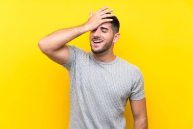 Genç yakışıklı adam, izole edilmiş sarı arka plan gülüyor.