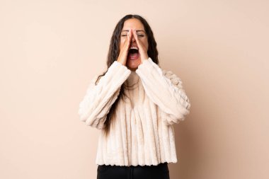 Izole arka plan üzerinde genç kadın bağırarak ve bir şey ilan