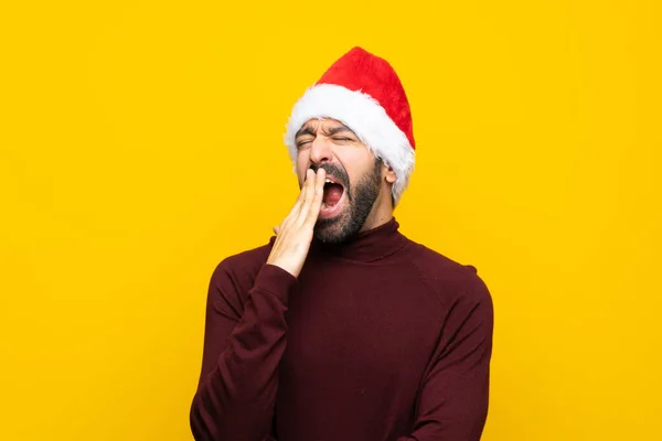 Человек Рождественской Шляпе Изолированном Желтом Фоне Зевает Закрывает Широко Открытый — стоковое фото