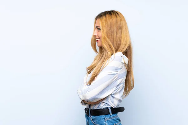 Mulher Loira Jovem Sobre Fundo Azul Isolado Posição Lateral — Fotografia de Stock