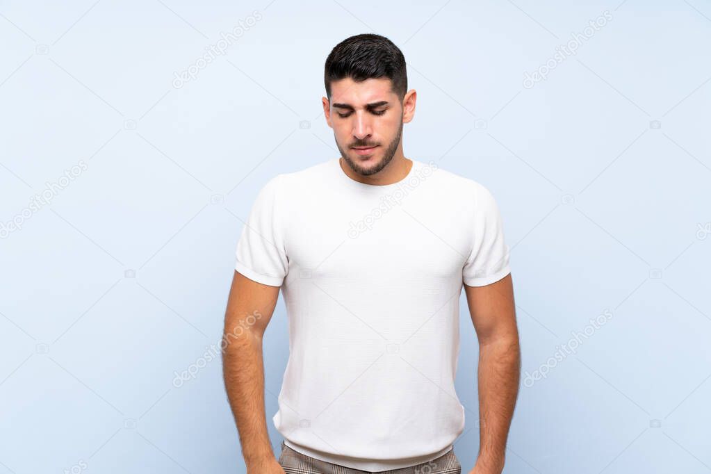 Caucasian handsome man over isolated blue background with sad and depressed expression