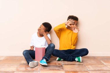 Afro-Amerikalı kardeşler ellerinde patlamış mısırlar tutuyorlar.