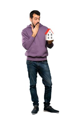 İzole beyaz arka plan üzerinde küçük bir ev tutarak kazak ile yakışıklı adamın tam uzunlukta atış