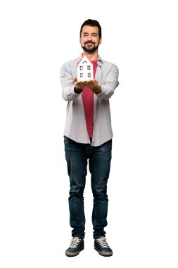 İzole beyaz arka plan üzerinde küçük bir ev tutarak sakallı yakışıklı adam tam uzunlukta atış