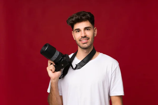 プロのカメラで隔離された背景の上に若い男 — ストック写真