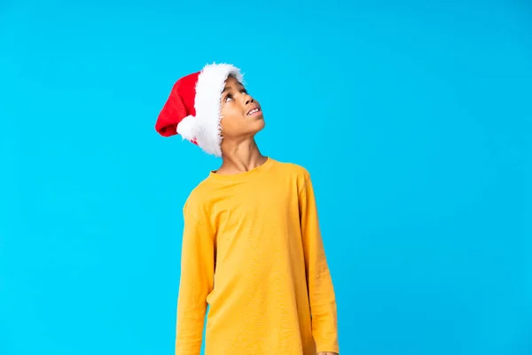 Niño Afroamericano Con Sombrero Navidad Mirando Hacia Arriba Mientras Sonríe —  Fotos de Stock
