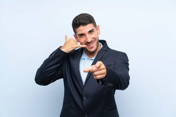 Hombre Guapo Sobre Fondo Azul Aislado Haciendo Gesto Teléfono Apuntando — Foto de Stock