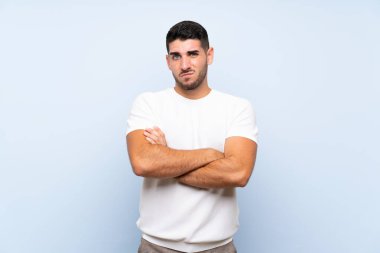 Kafkasyalı yakışıklı adam soyutlanmış mavi arka planda üzgün