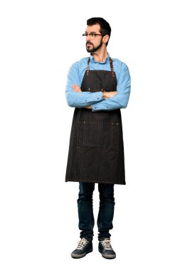 İzole edilmiş beyaz arka plan üzerinde önlük portresi olan bir adamın tam boy fotoğrafı.