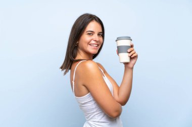 Genç kadın izole mavi arka plan üzerinde kahve götürmek tutarak