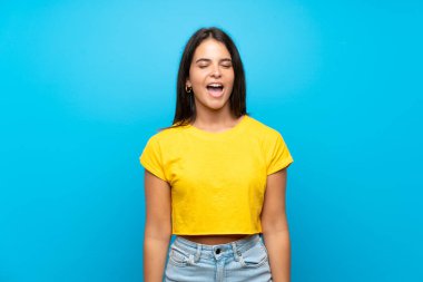 Soyutlanmış mavi arka planda genç bir kız ağzı açık bağırıyor.