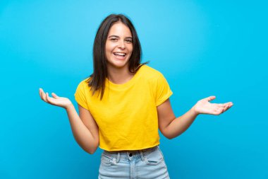 Izole mavi arka plan üzerinde genç kız çok gülümsüyor