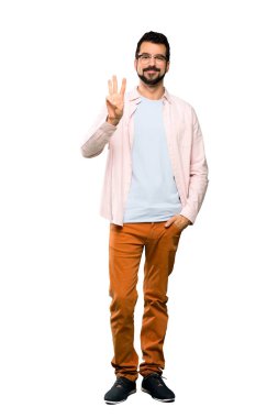 Sakallı, yakışıklı bir adamın tam boy fotoğrafı mutlu ve üç parmaklı, izole beyaz arka planda.