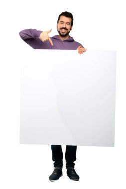 Boş bir afişini izole beyaz arka plan üzerinde tutarak kazak ile yakışıklı adamın tam uzunlukta atış