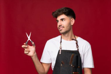 Tecrit edilmiş bir geçmişi olan genç bir adam kuaför ya da berber elbisesi yukarı bakıyor.