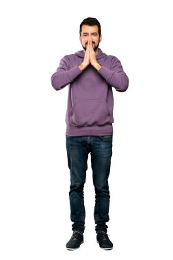 Sweatshirt 'lü yakışıklı adamın uzun pozu avuç içlerini bir arada tutar. İnsan izole edilmiş beyaz bir arkaplan ister