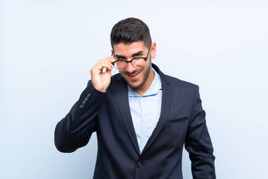 Gözlük ve şaşırttı ile izole mavi arka plan üzerinde Yakışıklı adam