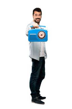 Bir radyo izole beyaz arka plan üzerinde tutarak sakallı yakışıklı adam tam uzunlukta atış