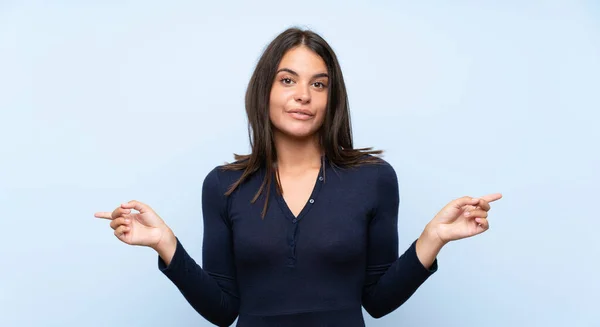 Jovencita Sobre Fondo Azul Aislado Apuntando Los Laterales Que Tienen — Foto de Stock