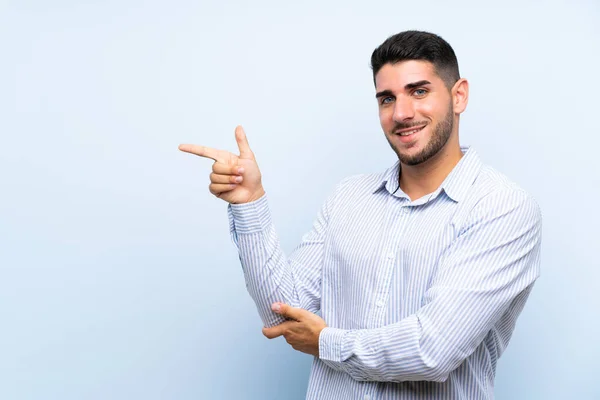 Kaukasische Knappe Man Geïsoleerde Blauwe Achtergrond Wijzende Vinger Aan Zijkant — Stockfoto