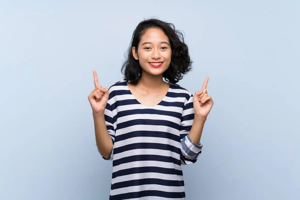 Asiatische Junge Frau Über Isolierten Blauen Hintergrund Zeigt Auf Eine — Stockfoto