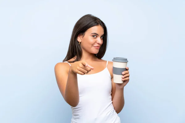Mladá Žena Drží Odnést Kávu Přes Izolované Modré Pozadí Ukazuje — Stock fotografie