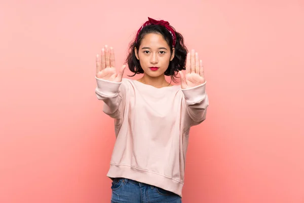 Soyutlanmış Pembe Arka Planda Asyalı Genç Bir Kadın Durdurma Hareketi — Stok fotoğraf