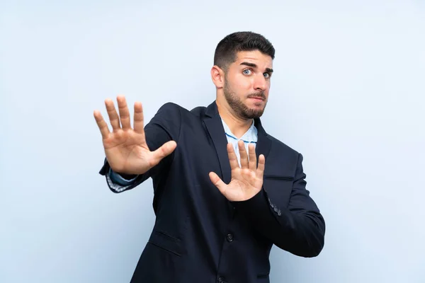 Bello Uomo Isolato Sfondo Blu Nervoso Tendendo Mani Davanti — Foto Stock