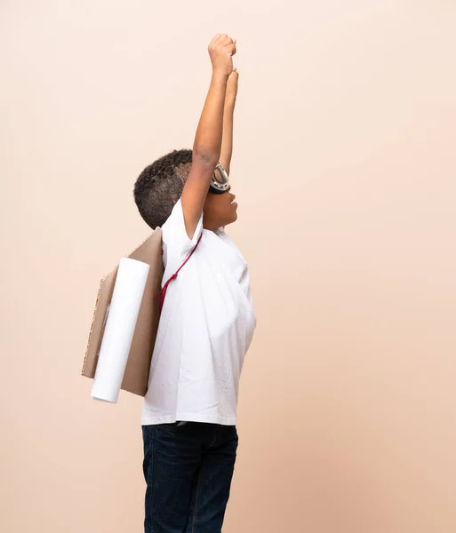 African American boy  with aviator hat and with wings over isolated background