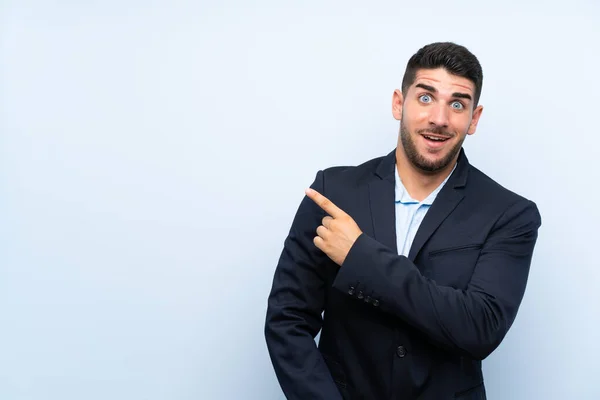 Hombre Guapo Sobre Fondo Azul Aislado Sorprendido Apuntando Lado —  Fotos de Stock