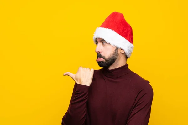 고립된 크리스마스 모자를 남자는 불행하게 사이드를 가리키며 — 스톡 사진