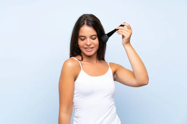 Chica joven sosteniendo cepillo de maquillaje sobre fondo aislado —  Fotos de Stock