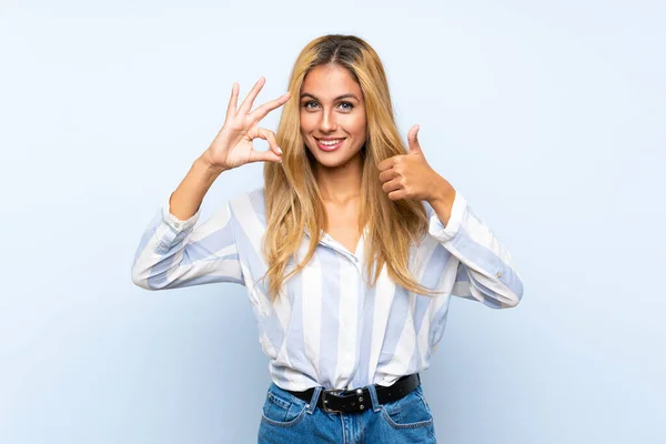 Joven Mujer Rubia Sobre Fondo Azul Aislado Mostrando Signo Pulgar —  Fotos de Stock