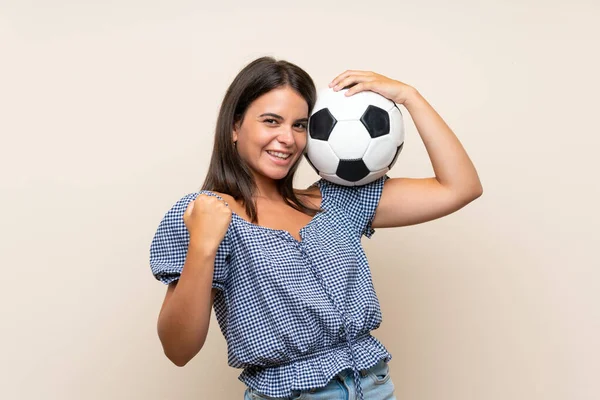 年轻的女孩在孤立的背景拿着一个足球 — 图库照片