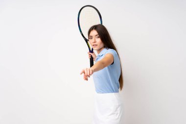 Tenis oynayan izole beyaz duvar üzerindeki genç kız
