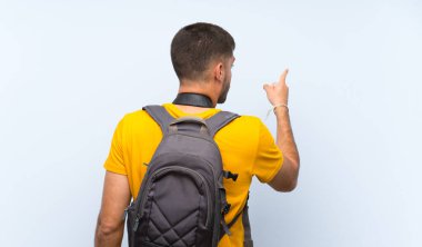 Genç fotoğrafçı işaret parmağıyla işaret ediyor.