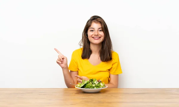 白种人女孩 有沙拉 手指指向侧面 — 图库照片