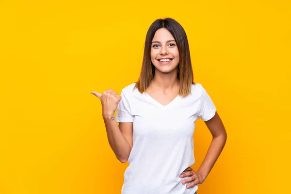 Giovane Donna Sfondo Giallo Isolato Che Punta Verso Lato Presentare — Foto Stock