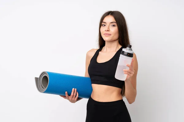 年轻的女运动员 穿着运动水瓶和垫子 站在孤立的白色背景上 — 图库照片