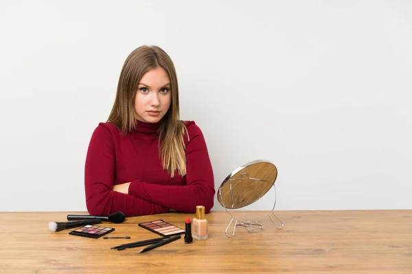 Menina Adolescente Com Paleta Maquiagem Cosméticos Uma Mesa Mantendo Braços — Fotografia de Stock